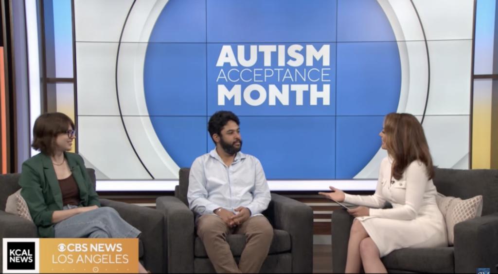 An interviewer on CBS news interviewing two Exceptional Minds studio artists